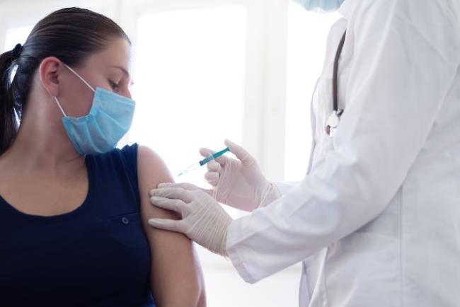 אישה צעירה עוברת חיסון נגד קורונה 